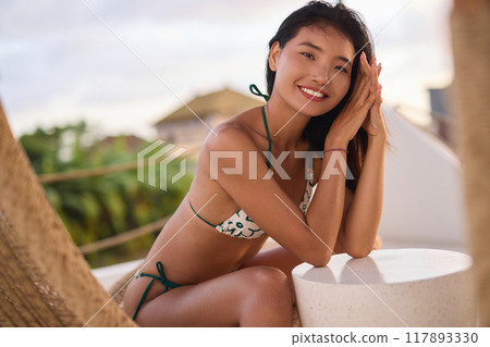 Smiling Woman Relaxing Outdoors in a Stylish Bikini on a Sunny Day 117893330