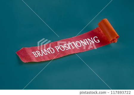 Economic concept. The inscription BRAND POSITIONING on an unfolded piece of paper Economic concept. The inscription BRAND POSITIONING on an unfolded piece of paper 117893722