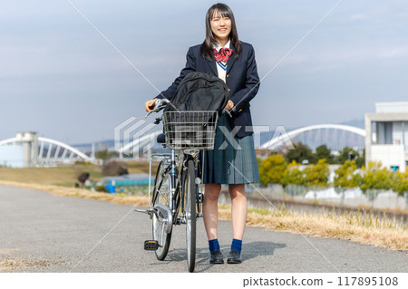 High school girl cycling to school 117895108