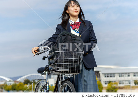 High school girl cycling to school 117895109