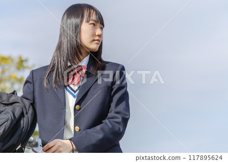 High school girl cycling to school High school girl cycling to school 117895624