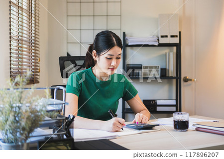 Woman working by using calculator. Woman working by using calculator. 117896207