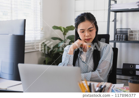 Businesswoman sitting at desk on couch in workplace  117896377