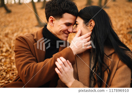 Young couple in love walking in the park on a autumn day. Enjoying time together. Young couple in love walking in the park on a autumn day. Enjoying time together. 117896910