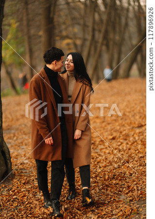 Young couple in love walking in the park on a autumn day. Enjoying time together. Young couple in love walking in the park on a autumn day. Enjoying time together. 117896926