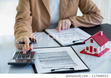 Real estate agent calculating house price for buyer. Real estate agent calculating house price for buyer. 117896933