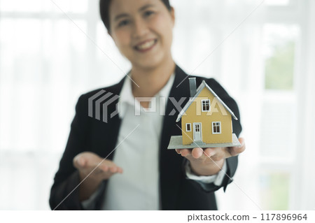 Real estate agent handing house model Real estate agent handing house model 117896964