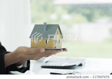 Real estate agent handing property keys to customer. Real estate agent handing property keys to customer. 117897070