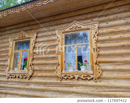 Wooden carved window frames, decorative elements of cornice of exhibition house, built on site of annual national Tatar holiday Sabantuy, in walking park with free access around clock, all year round 117897412