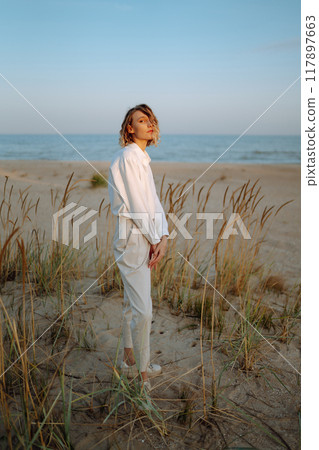 Stylish woman enjoying autumn weather outdoor. Fashion, style concept. People, lifestyle, relaxation Stylish woman enjoying autumn weather outdoor. Fashion, style concept. People, lifestyle, relaxation 117897663