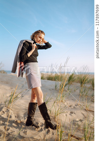Fashion Model posing near the sea. Young woman resting in nature. People, lifestyle, relaxation. 117897699