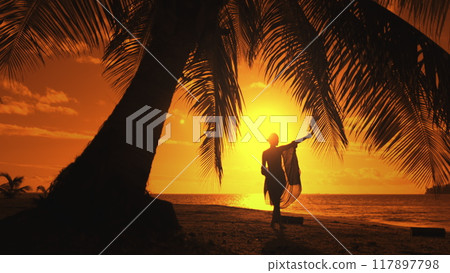 Woman is dancing on a beach at sunset, enjoying the beauty and peace of nature. The image evokes feelings of freedom, joy, and serenity 117897798