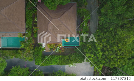 Relax on a yellow pool float in a tropical resort. Enjoy sunbathing in a serene oasis with lush greenery and blue waters. Perfect spot for a leisurely vacation escape 117897813