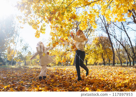 Stylish mother and daughter enjoy the autumn park. Family on a walk. Childhood, walks, rest. Stylish mother and daughter enjoy the autumn park. Family on a walk. Childhood, walks, rest. 117897953