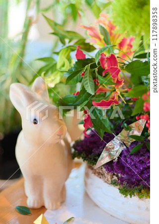Rabbit figurine and flower arrangement Rabbit figurine and flower arrangement 117898358