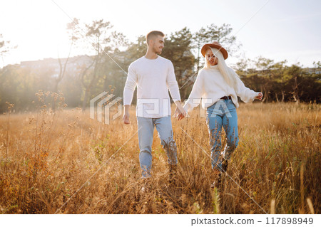 Young couple having fun walking and hugging n the park. Autumn weather. Relaxation, youth. Young couple having fun walking and hugging n the park. Autumn weather. Relaxation, youth. 117898949