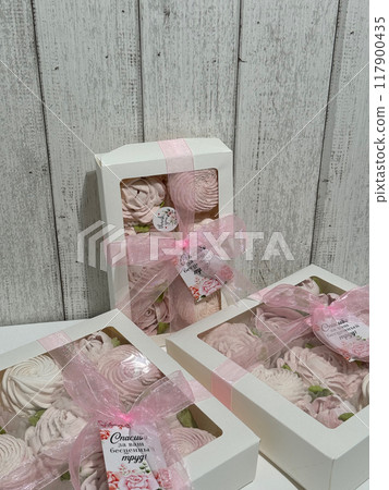 Three boxes of homemade marshmallows. Tied with a ribbon. The tags have the inscription in Russian Thank you for your invaluable work Flowers made of marshmallow. Close up. Three boxes of homemade marshmallows. Tied with a ribbon. The tags have the inscription in Russian Thank you for your invaluable work Flowers made of marshmallow. Close up. 117900435