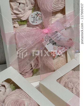 Three boxes of homemade marshmallows. Tied with a ribbon. The tags have the inscription in Russian Thank you for your invaluable work Flowers made of marshmallow. Close up. Three boxes of homemade marshmallows. Tied with a ribbon. The tags have the inscription in Russian Thank you for your invaluable work Flowers made of marshmallow. Close up. 117900437