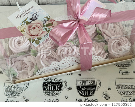 A box of homemade marshmallows. Tied with a ribbon. The tag has the inscription in Russian Unforgettable emotions. Flowers made of marshmallow. A box of homemade marshmallows. Tied with a ribbon. The tag has the inscription in Russian Unforgettable emotions. Flowers made of marshmallow. 117900595