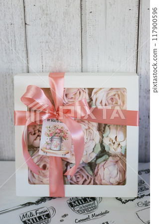 A box of homemade marshmallows. Tied with a ribbon. The tag has the inscription in Russian From the bottom of my heart. Flowers made of marshmallow. A box of homemade marshmallows. Tied with a ribbon. The tag has the inscription in Russian From the bottom of my heart. Flowers made of marshmallow. 117900596