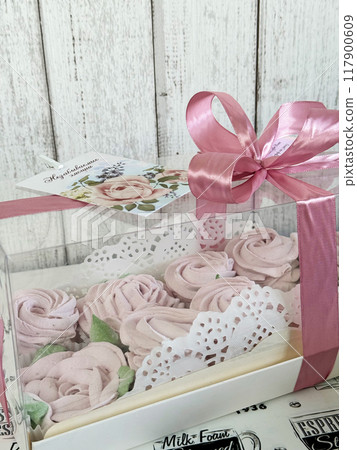A box of homemade marshmallows. Tied with a ribbon. The tag has the inscription in Russian Unforgettable emotions. Flowers made of marshmallow. A box of homemade marshmallows. Tied with a ribbon. The tag has the inscription in Russian Unforgettable emotions. Flowers made of marshmallow. 117900609