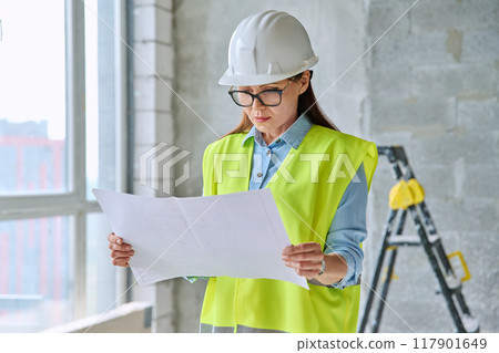 Technical profession woman in protective vest helmet working on construction 117901649