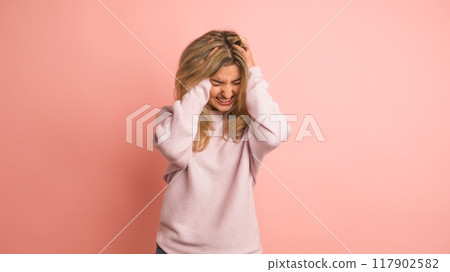Woman gesturing headache hands on head 117902582