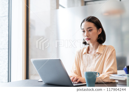 一個在電腦上工作的女人 117904244