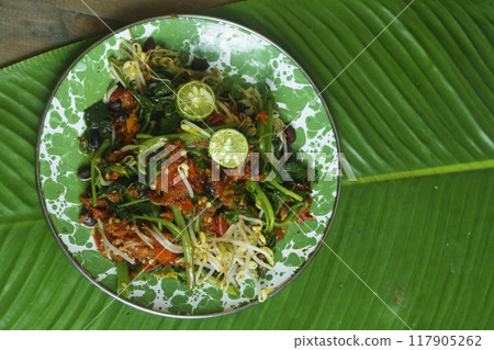 A vibrant plate of Plecing Kangkung, Lombok, Indonesian traditional food. A vibrant plate of Plecing Kangkung, Lombok, Indonesian traditional food. 117905262