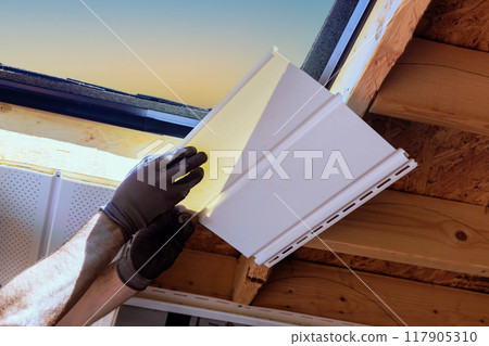 Nailing upvc soffit board installation at roof corner roof rafters ceiling on house Nailing upvc soffit board installation at roof corner roof rafters ceiling on house 117905310