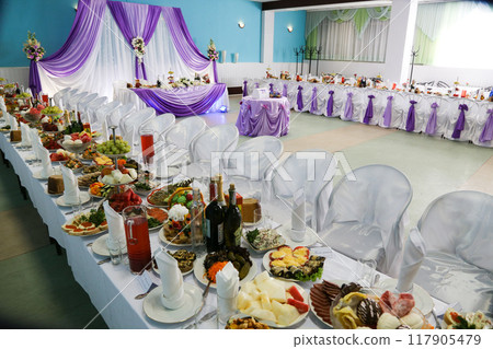 Restaurant with decorated and served tables with food. 117905479
