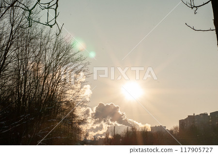Smoke from a chimney against the background of a sunny sky. 117905727