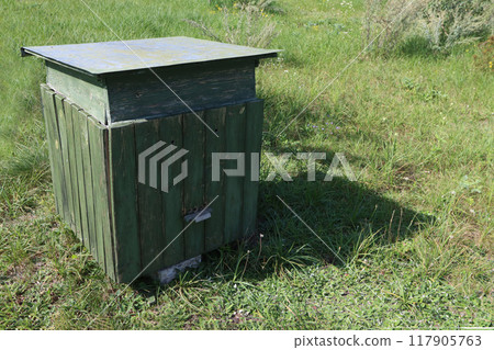 A bee hive on green grass. 117905763