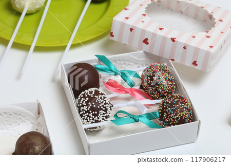 Cake pops decorated with a bow of braid, packed in a gift box. Cake pops decorated with a bow of braid, packed in a gift box. 117906217