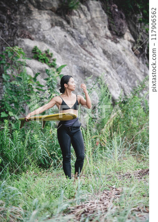 Young woman in nature with a surfboard 117906562