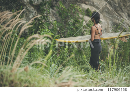 大自然中帶著衝浪板的年輕女子 117906568