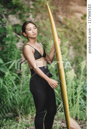 大自然中帶著衝浪板的年輕女子 117906583