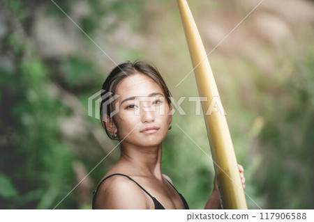 Young woman in nature with a surfboard 117906588