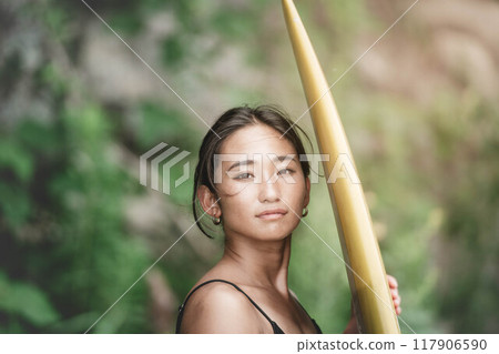 Young woman in nature with a surfboard 117906590