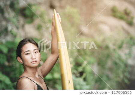 大自然中帶著衝浪板的年輕女子 117906595
