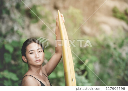 大自然中帶著衝浪板的年輕女子 117906596