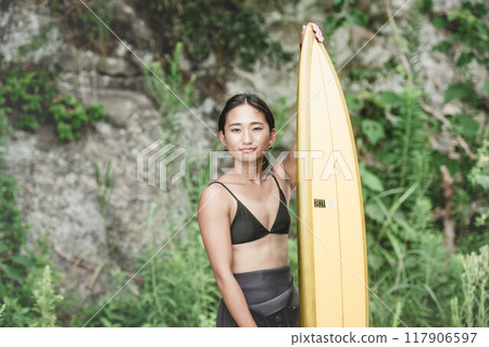 Young woman in nature with a surfboard Young woman in nature with a surfboard 117906597