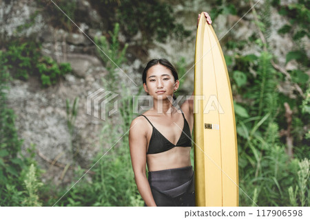 Young woman in nature with a surfboard 117906598