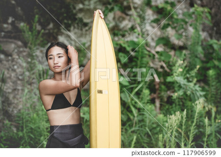 大自然中帶著衝浪板的年輕女子 117906599