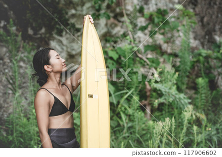 Young woman in nature with a surfboard 117906602