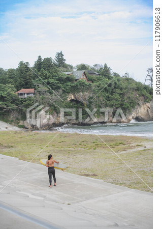 拿著衝浪板沿著海灘散步的年輕女子 117906618