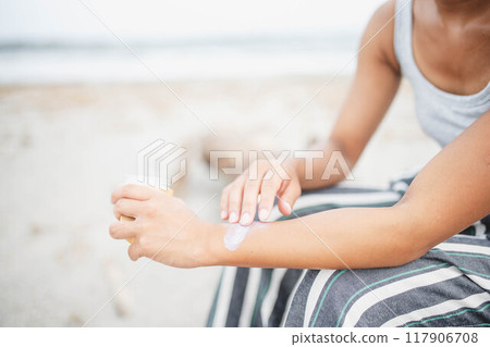 Young woman doing skin care at the beach 117906708