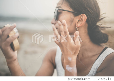 Young woman doing skin care at the beach 117906715