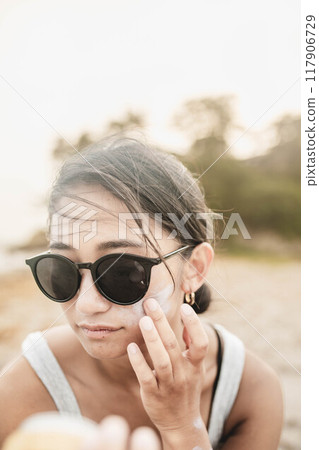 Young woman doing skin care at the beach 117906729