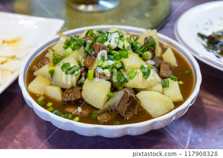 Simple and authentic Sichuan cuisine of braised chunk beef with potato topped with scallion Simple and authentic Sichuan cuisine of braised chunk beef with potato topped with scallion 117908328